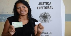 Jovem eleitora exibe o título eleitoral após a votação